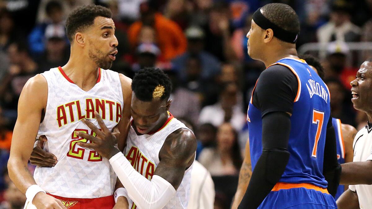 Hawks forward Thabo Sefolosha (25) is held back by teammate Dennis Schroder after a confrontation with Knicks forward Carmelo Anthony (7) during the second quarter.