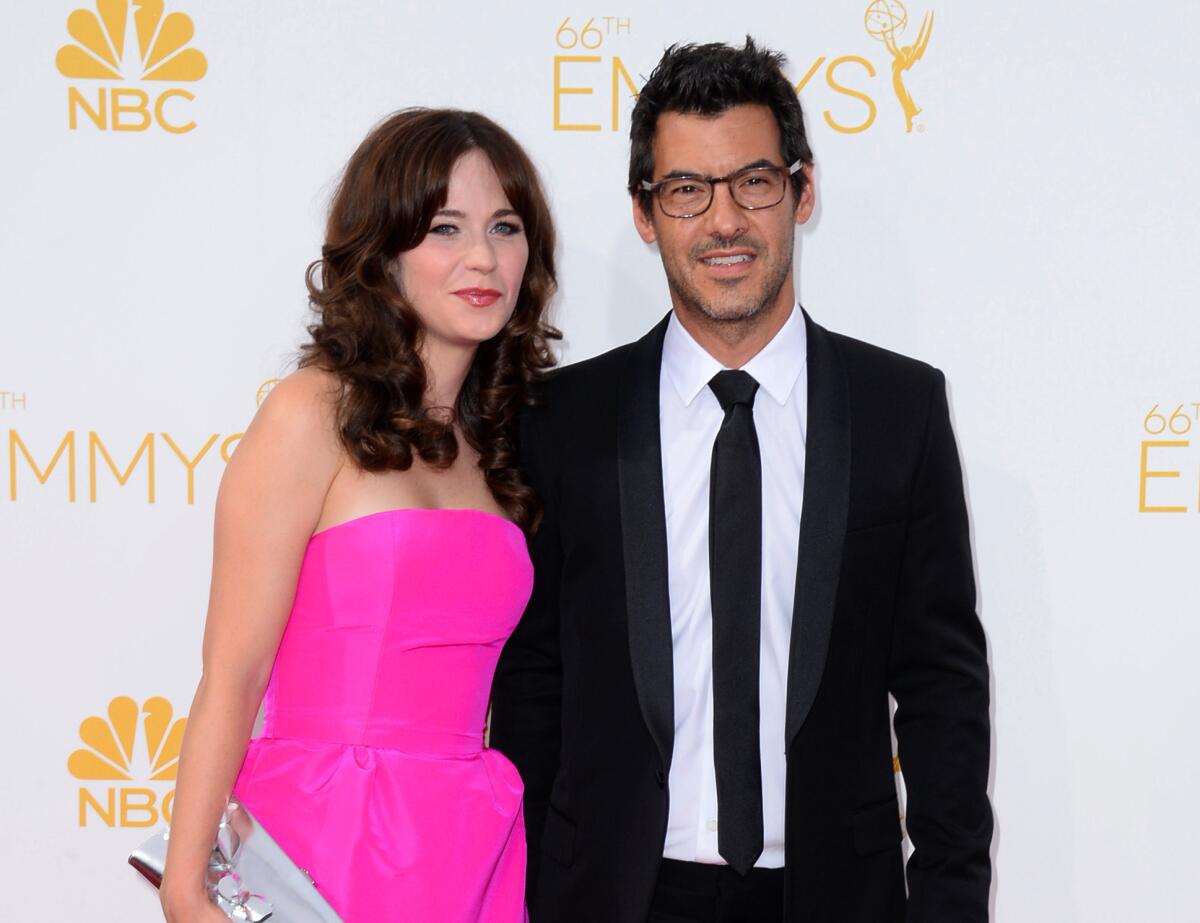 Zooey Deschanel, left, and Jacob Pechenik arrive at the 66th Primetime Emmy Awards at the Nokia Theatre L.A. Live on Aug. 25, 2014, in Los Angeles.