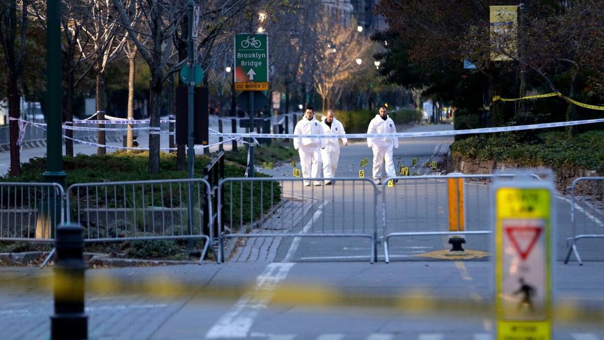 Emergency officials walk near evidence markers on the west side bike path in lower Manhattan, New York on Nov. 1.