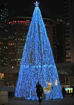 China A woman holding a shopping bag walks past a Christmas tree in front of commercial and residential apartment blocks in Beijing.
