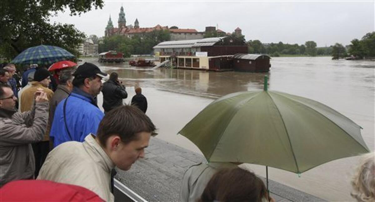 People stand on the embankment of the flooded river Wisla in the city of Krakow in Southern Poland,on Tuesday, May 18, 2010. Five persons have drowned and over 2000 have been evacuated as weather forecasts predict more rain in the coming days.Heavy rains that began in central Europe last weekend also are causing flooding in areas of Hungary, Slovakia and the Czech Republic, with rivers bursting their banks and inundating low-lying homes and roads, and cutting off villages. (AP Photo/str)