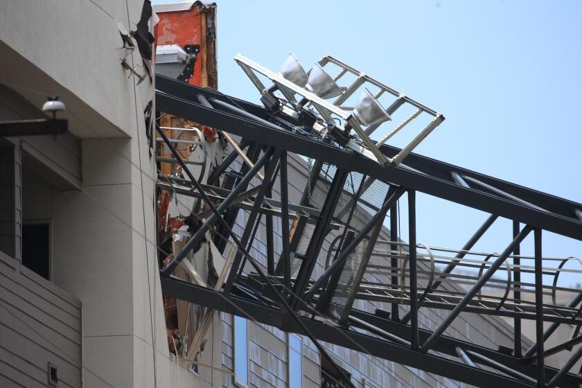 Officials respond to the scene after a crane collapsed into Elan City Lights apartments amid severe thunderstorms, Sunday, June 9, 2019, in Dallas. Injuries were reported Sunday afternoon when storms pummeled parts of North Texas. (Shaban Athuman/The Dallas Morning News via AP)