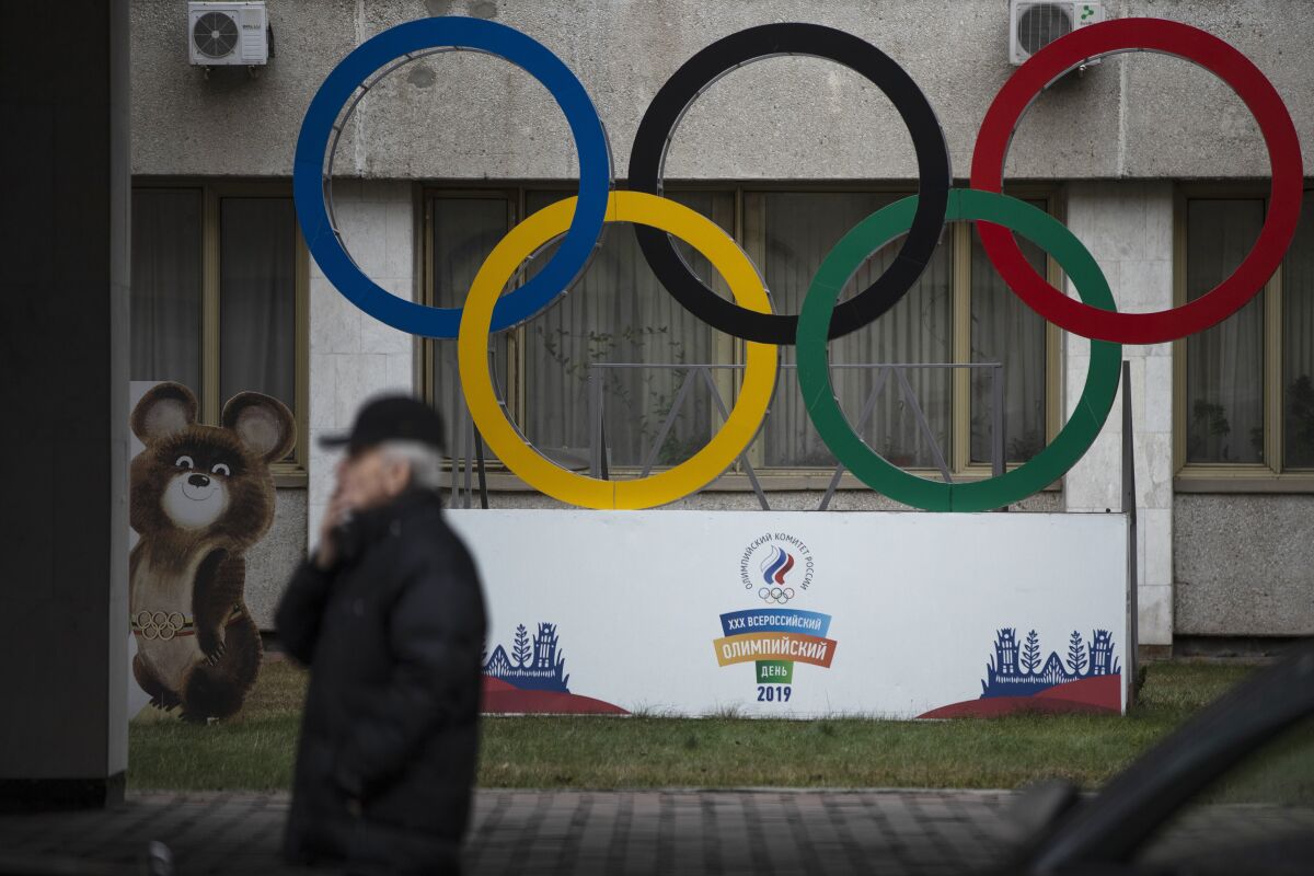 FILE - In this Nov. 28, 2019 file photo Olympic Rings and a model of Misha the Bear Cub, the mascot of the Moscow 1980 Olympic Games, left, are seen in the yard of Russian Olympic Committee building in Moscow, Russia. Russia’s status as an Olympic team and reputation as a serial cheater in international sports goes on trial next week, in the latest legal fallout from state-backed doping dating back several years. The Court of Arbitration for Sport judges will start on Monday Nov. 2, 2020, hearing evidence about a manipulated database from the Moscow testing laboratory. (AP Photo/Pavel Golovkin, file)