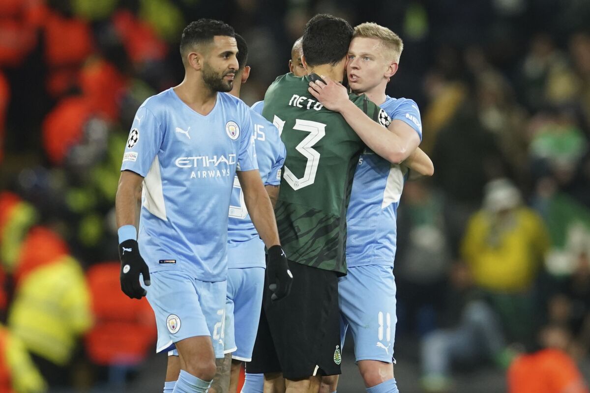Manchester City's Oleksandr Zinchenko, right, embraces Sporting's Luis Neto after the Champions League round of 16 second leg soccer match between Manchester City and Sporting Lisbon at the City of Manchester Stadium in Manchester, England, Wednesday, March 9, 2022. (AP Photo/Dave Thompson)