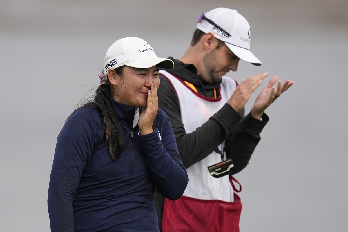 Allisen Corpuz wipes away tears as she walks off the 18th green with her caddie after winning the U.S. Women's Open.