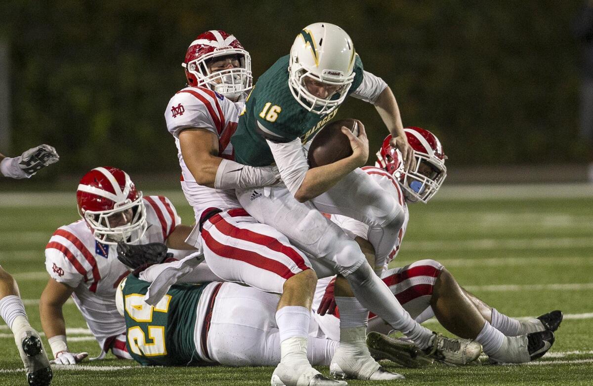 Edison High’s Griffin O’Connor is sacked by Mater Dei’s Syrr Barnes during the Monarchs’ win at Orange Coast College on Friday.