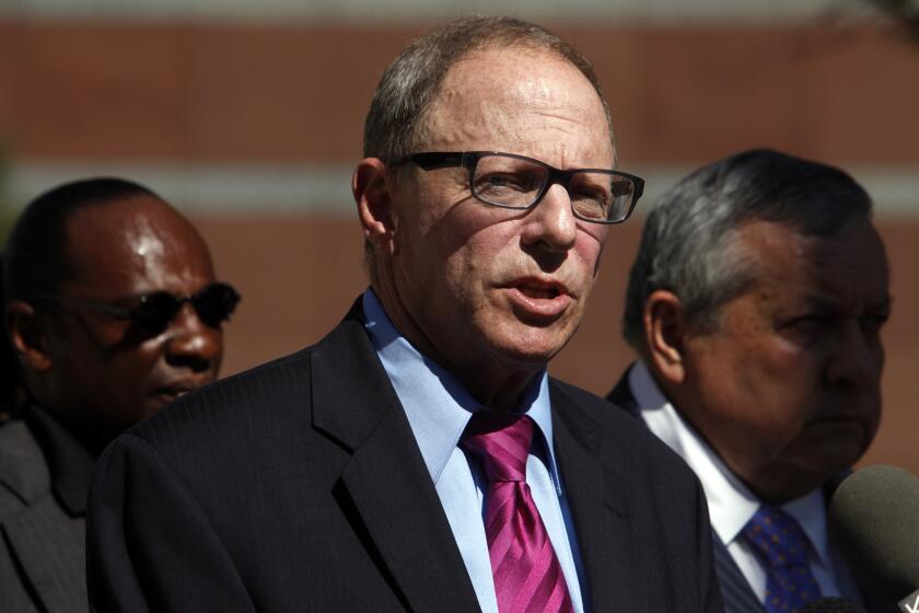 Attorney Steven Lerman, center, announces the filing of a federal lawsuit seeking punitive and compensatory damages and a claim against Los Angeles for $75 million on behalf of the family of Ezell Ford, who was shot and killed by LAPD officers.