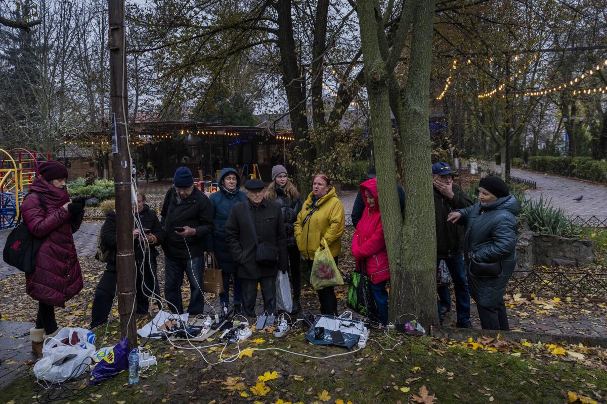 Residents plug in mobile phones and power banks at an outdoor charging point.