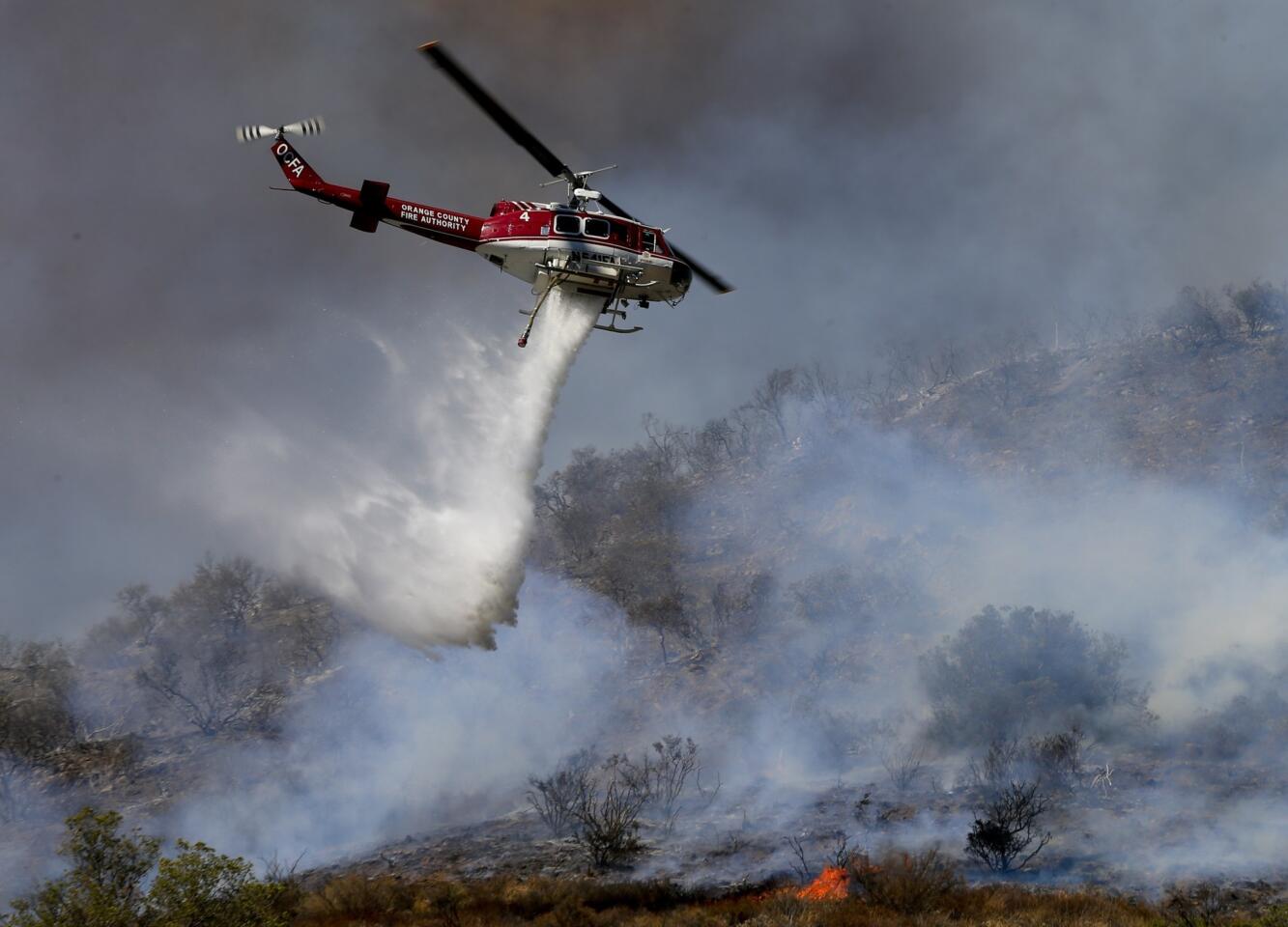 More than 280 firefighters are aided by water dropping helicopters and fixed-wing aircraft as they battle a 1,300-acre fire in Silverado Canyon.