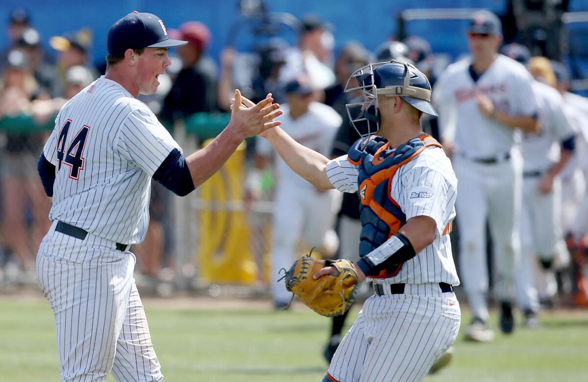 Fullerton pitcher John Gavin and catcher Chris Hudgins celebrate after defeating Long Beach State on Saturday.
