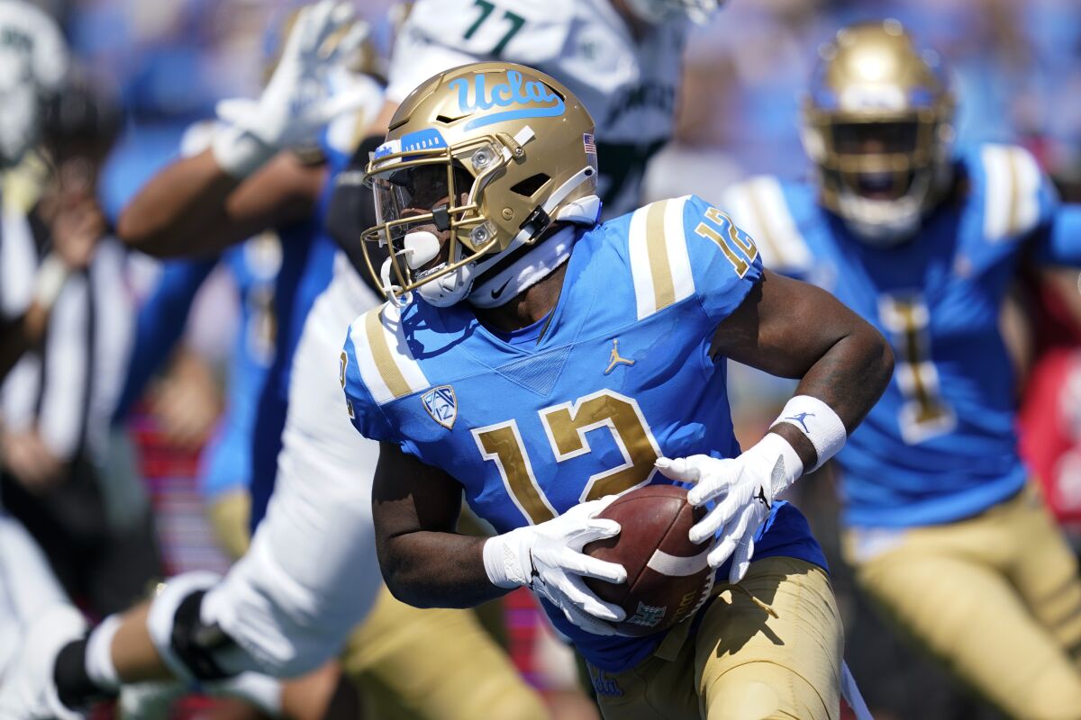 UCLA defensive back Martell Irby runs with the ball after intercepting a pass.
