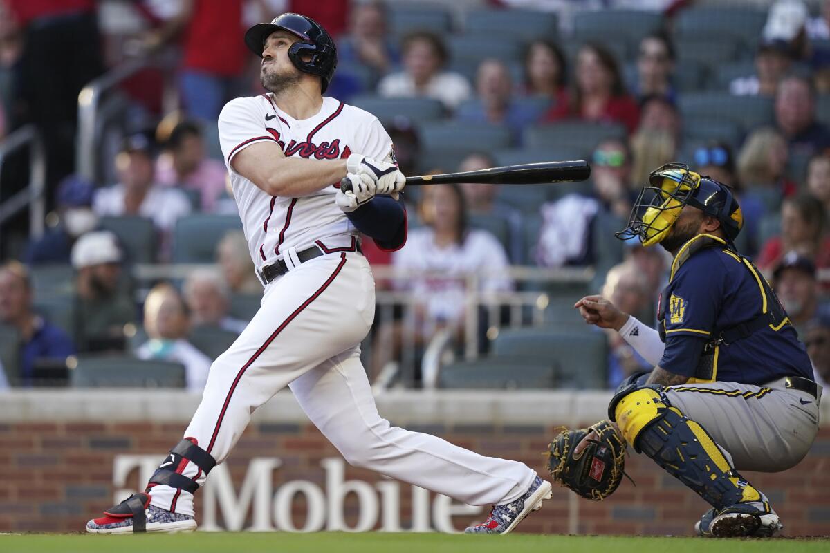 Atlanta Braves' Adam Duvall hits a single against the Milwaukee Brewers during Game 4 