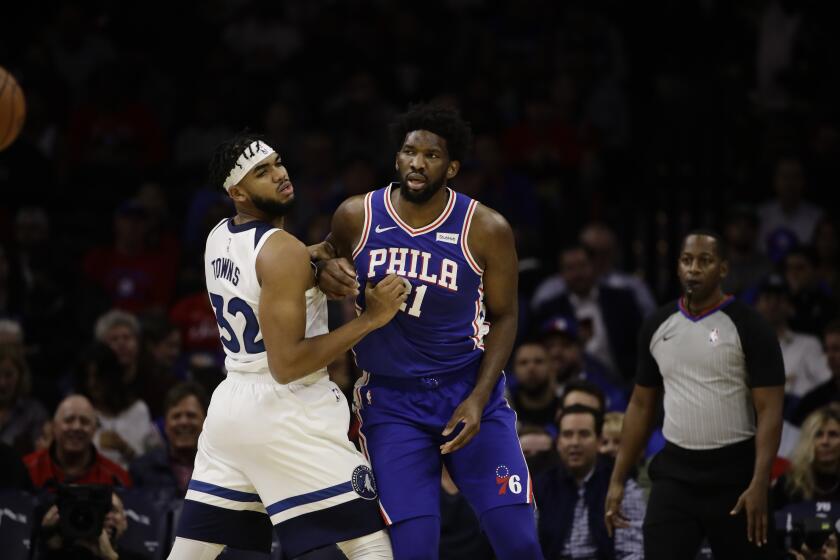 Minnesota's Karl-Anthony Towns and Philadelphia's Joel Embiid fight for post position during their game on Oct. 30, 2019. 