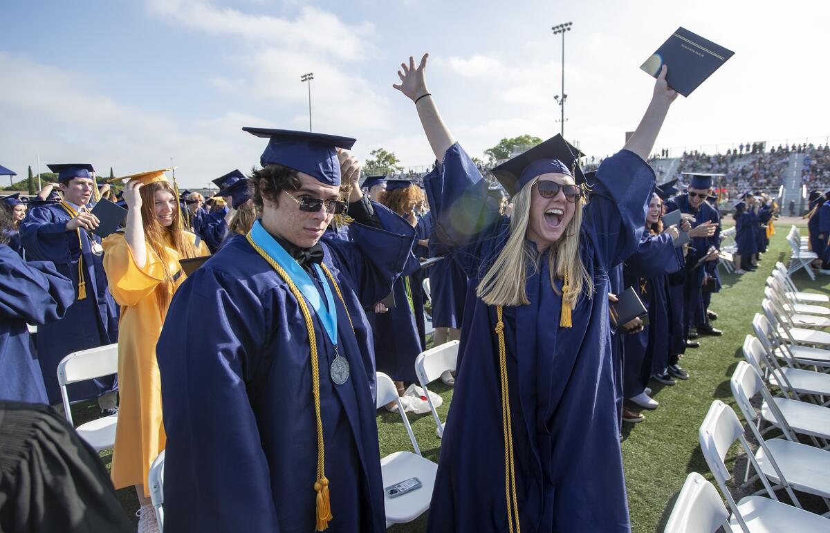 A graduate raises her hands in joy during the Marina High commencement ceremony at Westminster High School on Thursday.