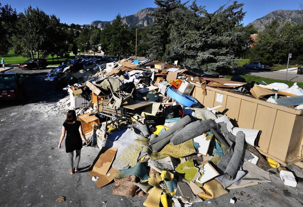 A woman looks for wood she can salvage after flooding in Boulder, Colo. Officials say damage in the city was much less than it could have been because of flood protection projects put in place since previous disasters.