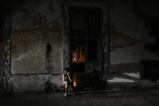 A resident sits while passing time during a blackout following the failure of a major power plant in Havana, Cuba, Saturday, Oct. 19, 2024. (AP Photo/Ramon Espinosa)