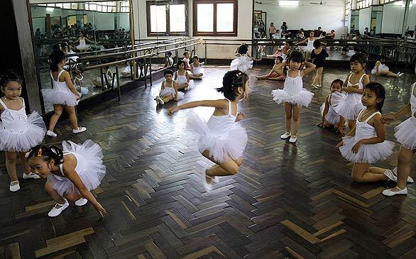 Young dancers take a break from class at the Children's Palace in Hanoi, Vietnam. The Children's Palace community project provides kids a place to go for summer education.