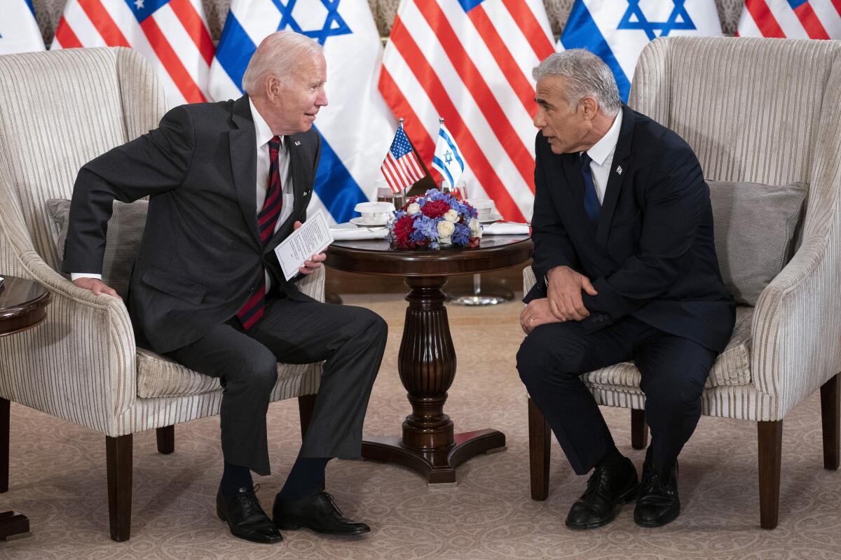 President Biden and Israeli Prime Minister Yair Lapid speak in front of U.S. and Israeli flags.