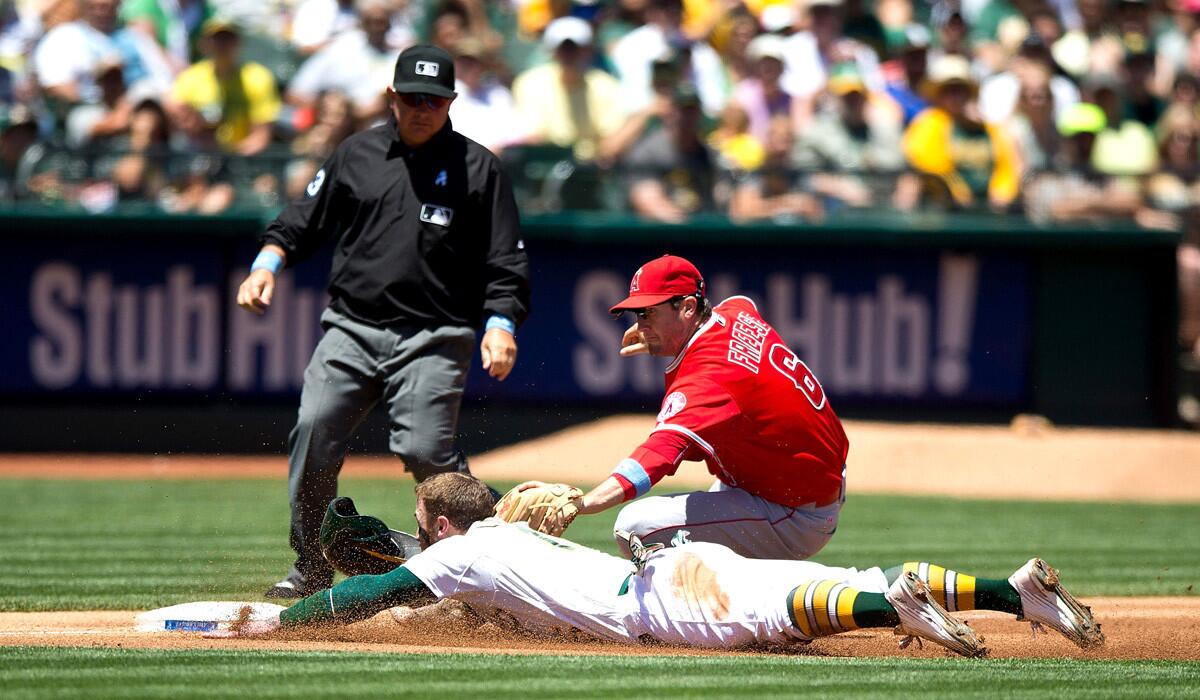Oakland Athletics' Brett Lawrie is tagged out attempting to steal third base by Los Angeles Angels of Anaheim's David Freese in front of umpire Greg Gibson during the second inning on Sunday. A's beat the Angels, 3-2.