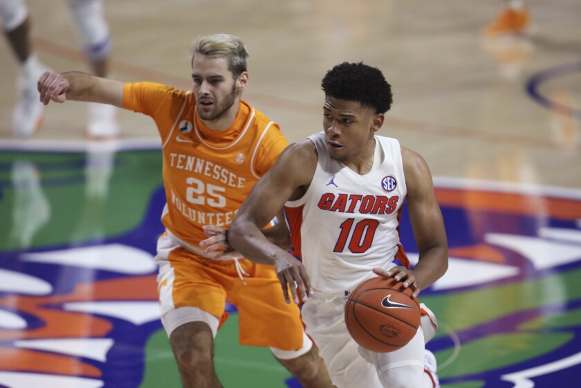 Florida guard Noah Locke works around Tennessee guard Santiago Vescovi.