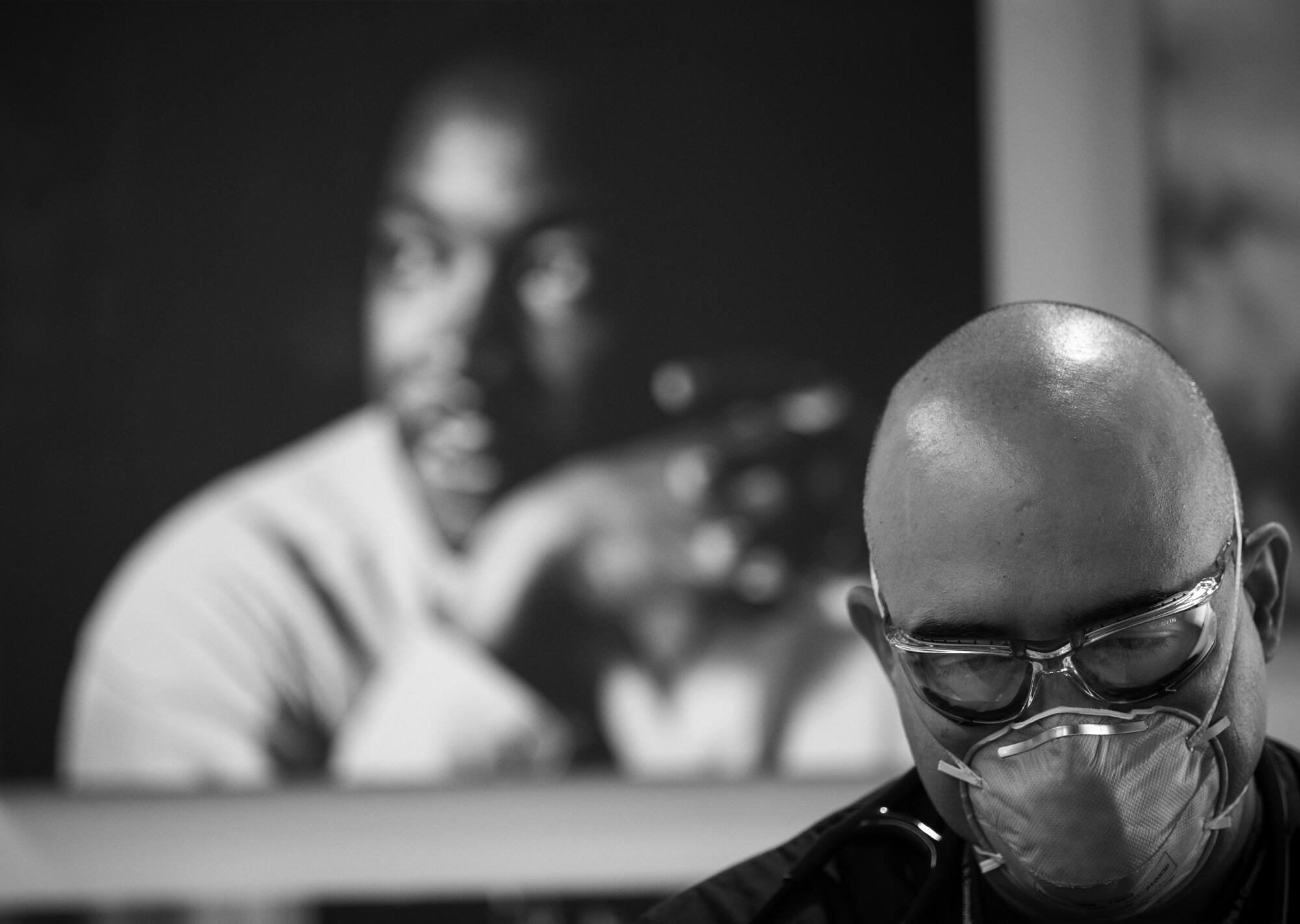 Under a portrait of the Rev. Martin Luther King Jr., Dr. Oscar Casillas tends to an ER patient at MLK Community Hospital.