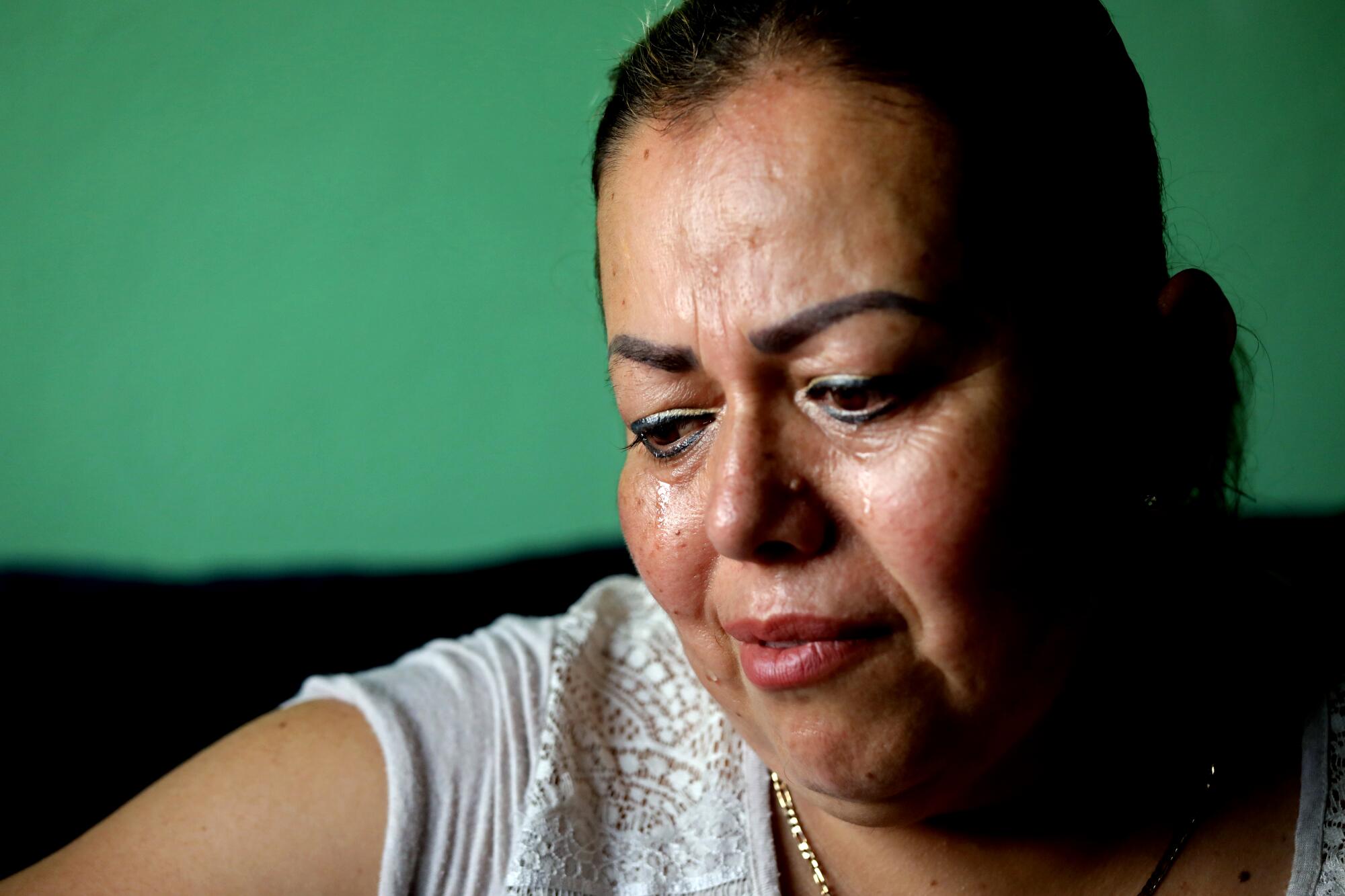 Josefina Rodriguez weeps while talking about her son and husband.
