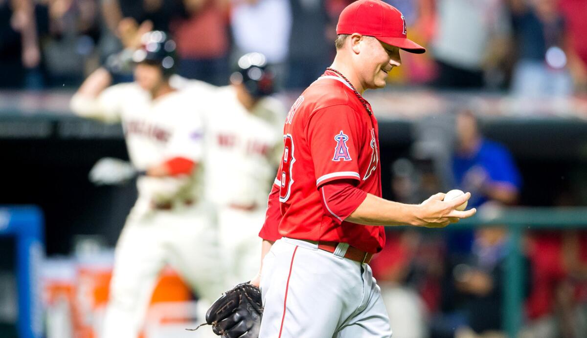 Angels reliever Joe Smith heads back to the mound with a new ball after Indians catcher Yan Gomes hit a grand slam in the eighth inning Saturday night in Cleveland.