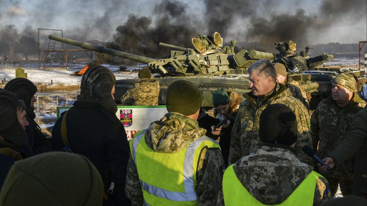 Ukrainian President Petro Poroshenko, second from right, speaks with soldiers training at a military base in the Chernihiv region on Nov. 28, 2018.