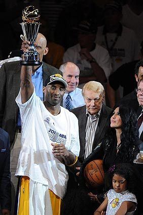Jerry Buss, center, stands between Kobe and Vanessa Bryant after the Lakers defeated the Boston Celtics to win the NBA title in 2010. Kobe is holding up the trophy he won as series MVP.
