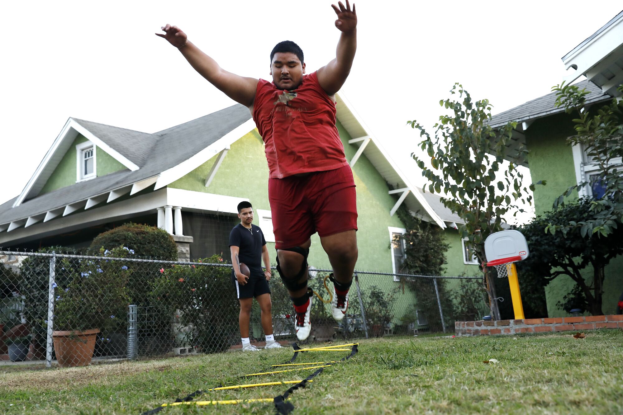 East L.A. Roosevelt players Benjamin Reyes, foreground, and Damian Avalos do a remote team workout.