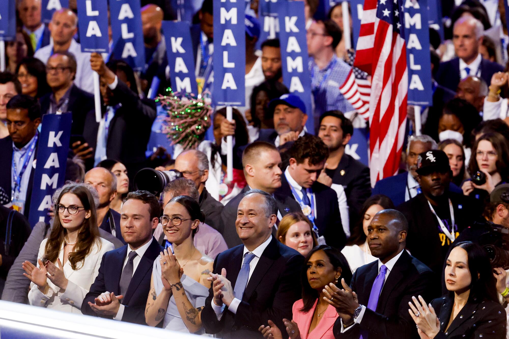 Second Gentleman Doug Emhoff, center, and other family members listen as Vice President Kamala Harris addresses the DNC.