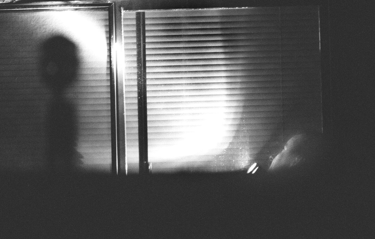 A San Diego County Sheriff's investigator shines a light at a window outside the Rancho Santa Fe mansion where 39 bodies of Heaven's Gate members were found on March 26, 1997.