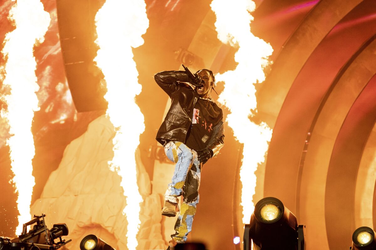 Travis Scott performs on a fiery concert stage