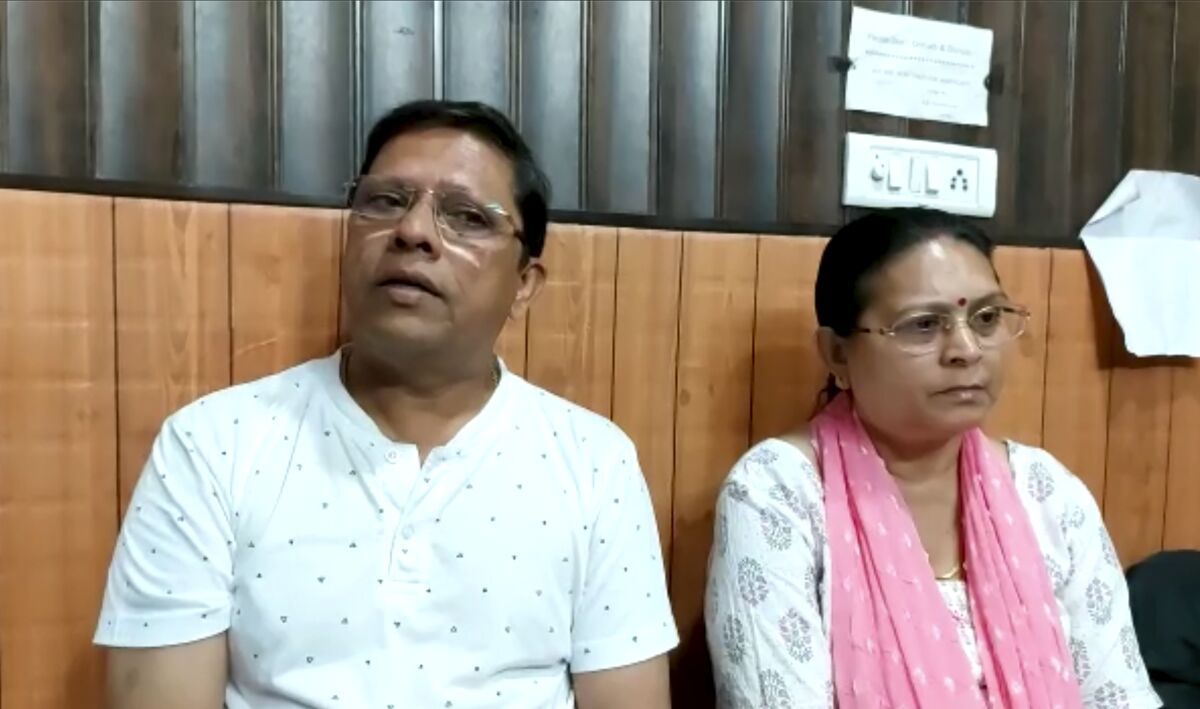 This image from video shows Sanjeev Ranjan Prasad, a 61-year-old retired government officer, and his wife Sadhana Prasad wait at a lawyer's chamber in Haridwar, India, Thursday, May 12, 2022. The Indian couple has sued their pilot son and daughter-in-law in a court demanding a grandchild within a year or compensation of 50 million rupees ($675,675). Prasad said this was an emotional and sensitive issue for him and his wife and they cannot wait any longer. His son got married six years ago. (KK Productions via AP)