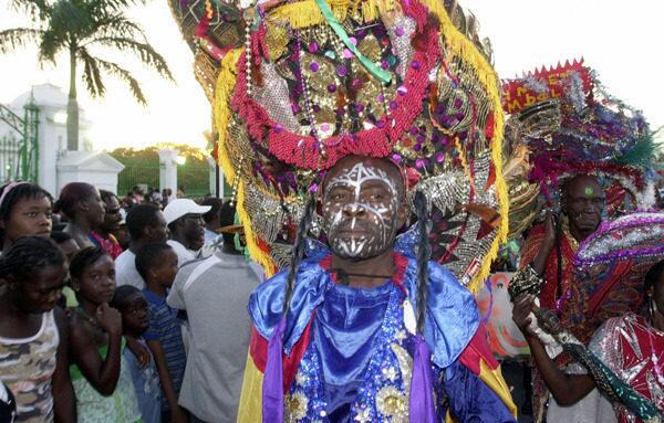 A Haitian man wears an elaborate headdress and makeup in a Carnival parade.
