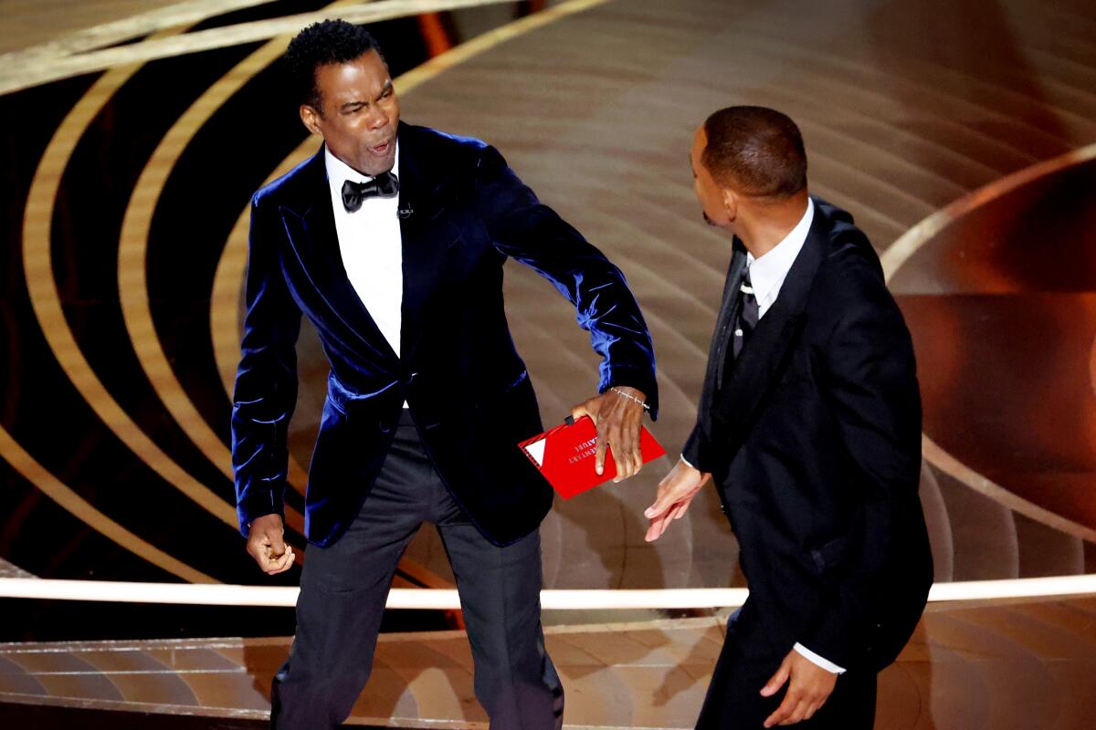  Chris Rock reacts after being struck by actor Will Smith onstage during the show 