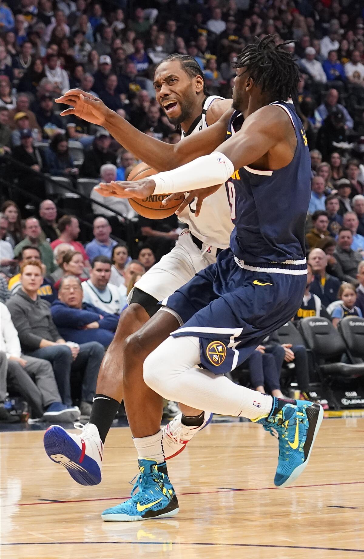 Clippers forward Kawhi Leonard drives to the basket against Nuggets forward Jerami Grant during the first quarter of a game Jan. 12 at the Pepsi Center.