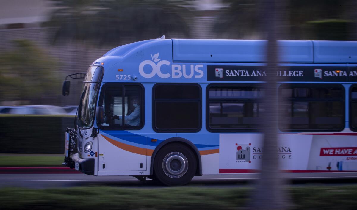 A blue and white bus on a road. 