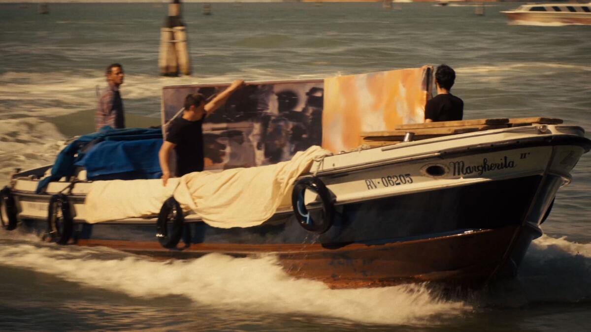 An image from the film "Taking Venice" large paintings being transported by water taxi.