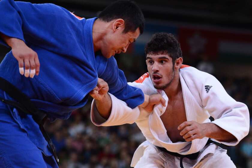 South Korea's Song Dae-nam, left, faces Cuba's Asley Gonzalez in the men's judo finals.