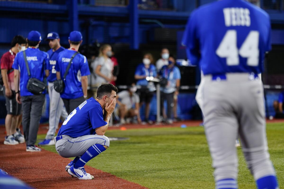 Israel's Alon Leichman kneels and reacts after a baseball game against the Dominican Republic at the Tokyo Olympics