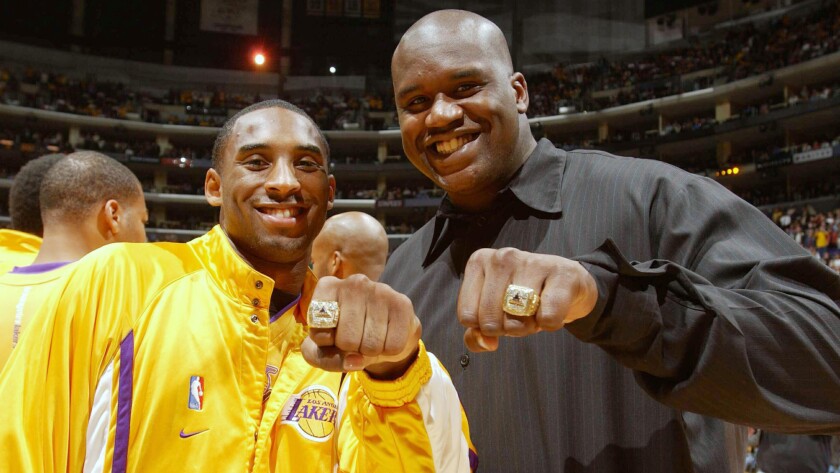 Lakers stars Kobe Bryant, left, and Shaquille O'Neal show off their 2002 NBA championship rings before a game against the San Antonio Spurs at Staples Center on Oct. 29, 2002.