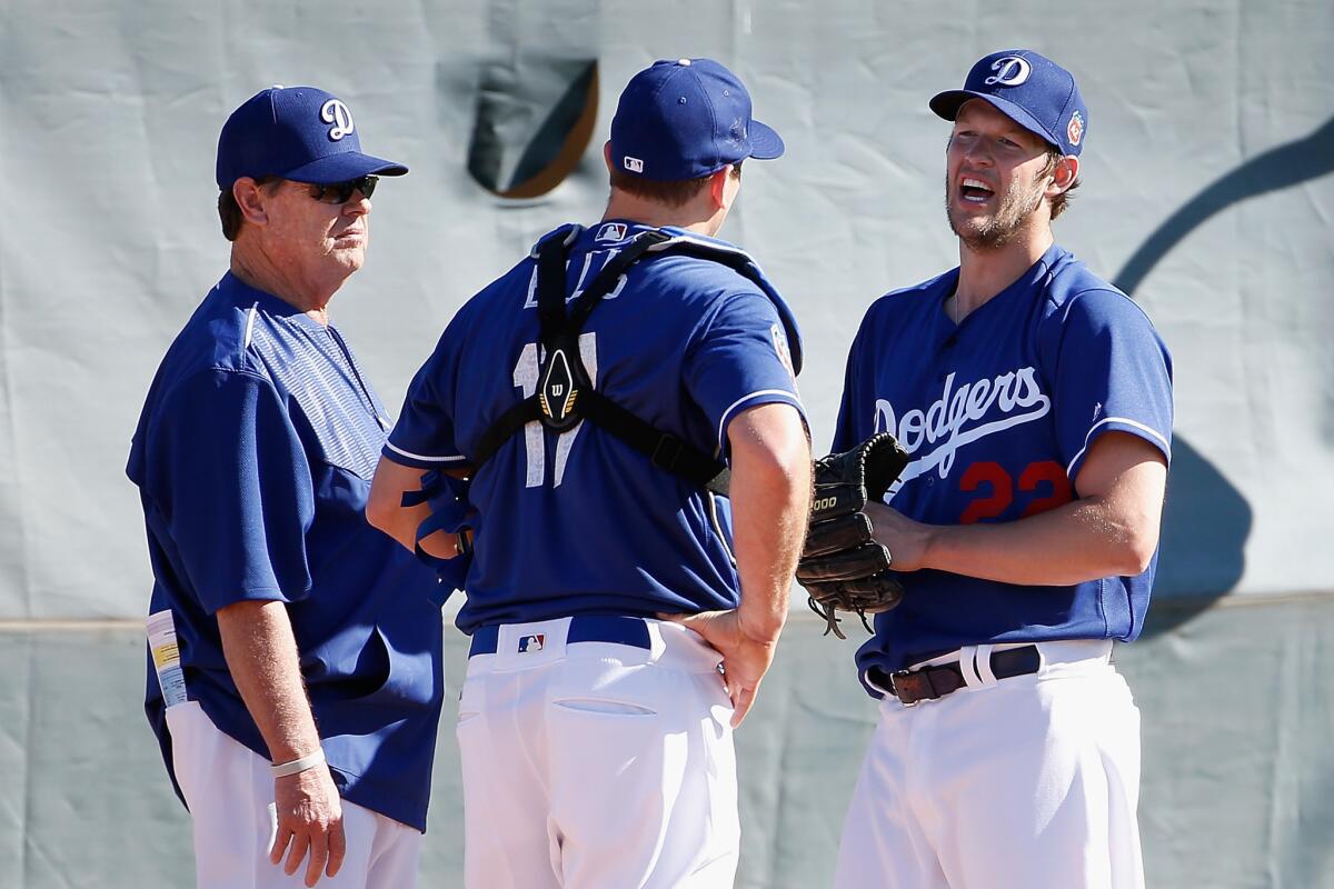 Dodgers starting pitcher Clayton Kershaw talks with pitching coach Rick Honeycutt and catcher A.J. Ellis during a spring training workout at Camelback Ranch on Feb. 20.