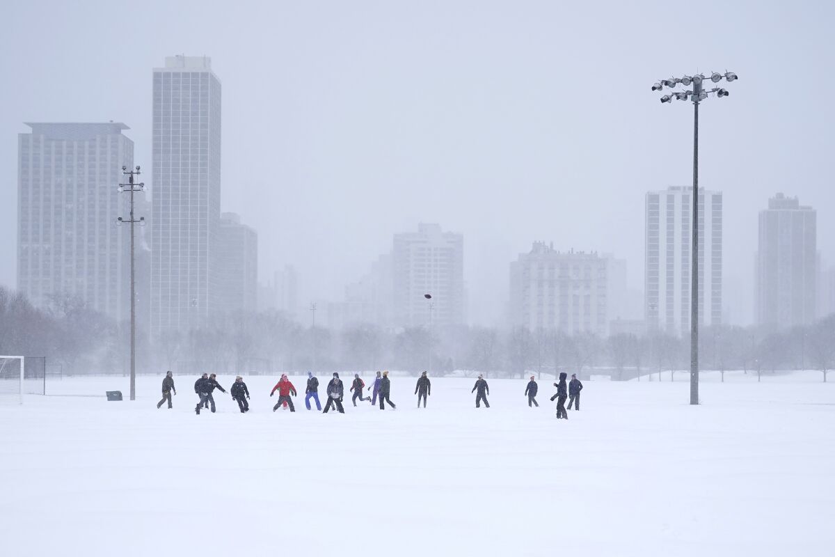 Men playing football on snow-covered field