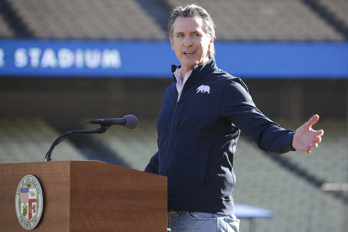 Gov. Gavin Newsom helps launch a mass COVID-19 vaccination site at Dodger Stadium in Los Angeles on Jan. 15, 2021.