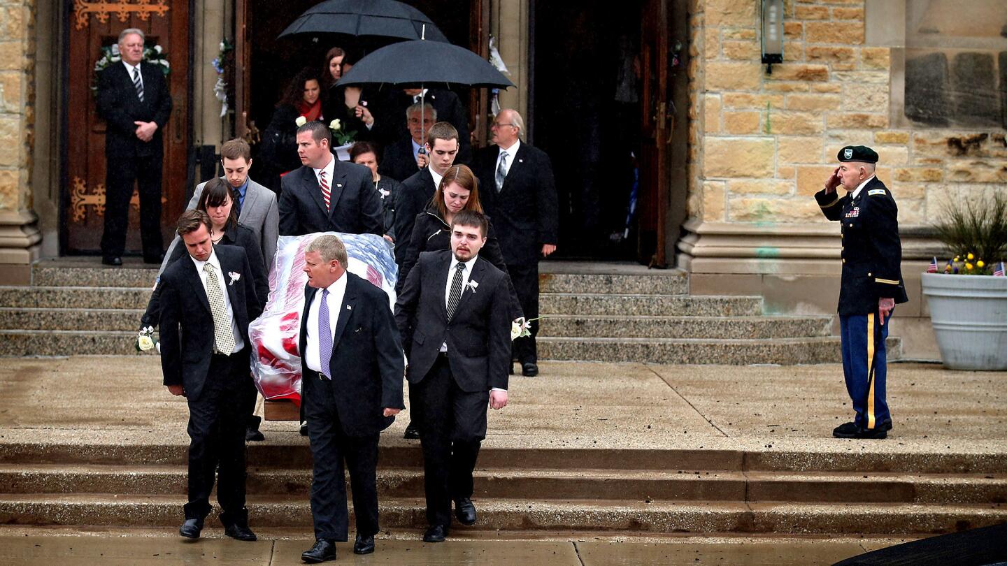 A soldier salutes as the coffin of Anne Smedinghoff, 25, is carried from St. Luke's Church in River Forest, Ill., on April 17, 2013, after her funeral service.