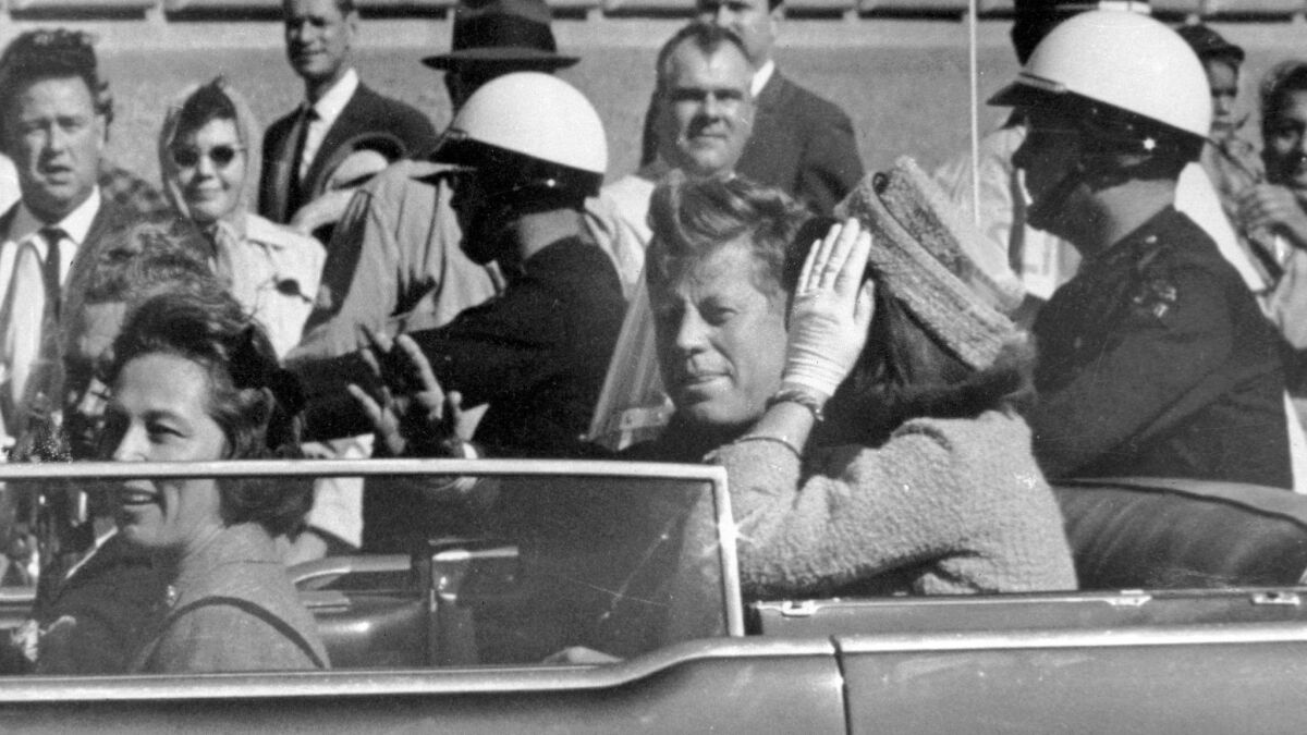 President John F. Kennedy waves from his car in a motorcade in Dallas on Nov. 22, 1963.