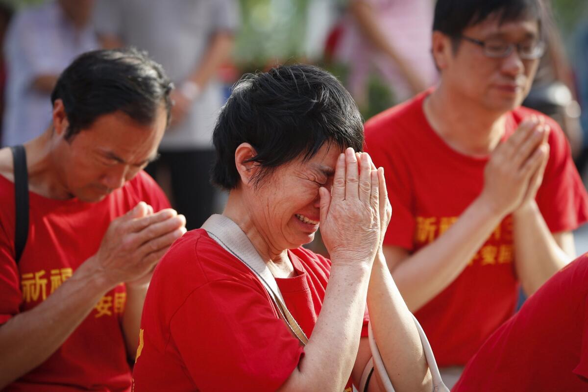 Chinese family members of passengers on board missing Malaysia Airlines Flight 370 cry as they pray at a temple in Kuala Lumpur, Malaysia, on March 1.