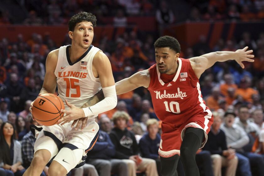 Illinois' RJ Melendez (15) works the ball inside against Nebraska's Jamarques Lawrence (10) during the first half of an NCAA college basketball game, Tuesday, Jan. 31, 2023, in Champaign, Ill. (AP Photo/Michael Allio)