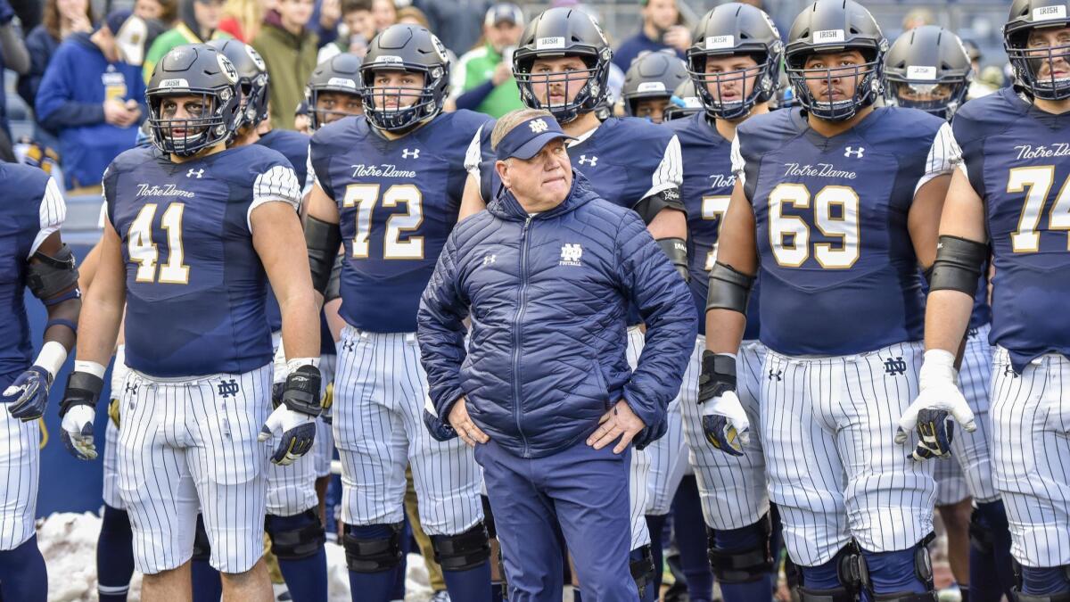 Notre Dame head coach Brian Kelly stands with his team before a game against Syracuse on Saturday at Yankee Stadium in New York.